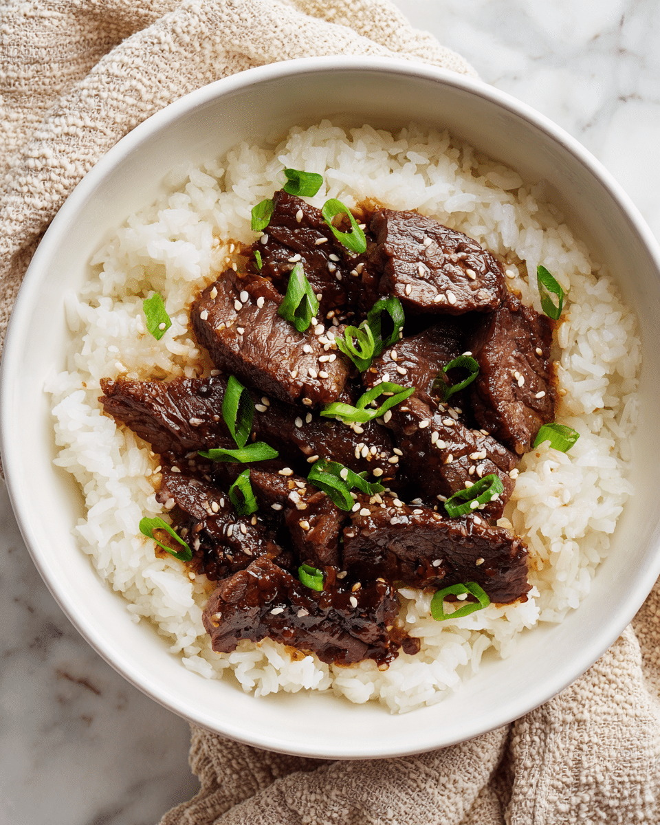 A white bowl filled with a base layer of cooked white rice, topped with several pieces of dark brown, cooked beef slices arranged closely together. The beef has a slightly shiny texture from the sauce. On top of the beef, there are small green chopped scallions and white sesame seeds scattered evenly. The bowl sits on a white marbled surface with a beige and white textured cloth partially visible beside it. photo taken with an iphone --ar 4:5 --v 7 — Keto Beef Bulgogi, Korean BBQ keto, low-carb beef bulgogi, keto Korean dishes, healthy beef bulgogi