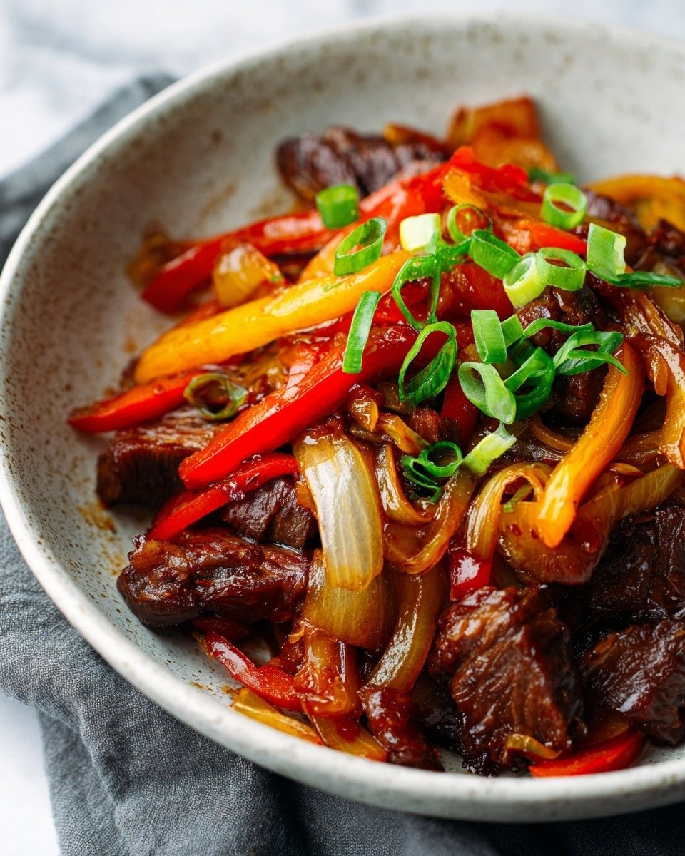 The dish is shown as a close-up in a white bowl with a speckled texture, placed on a white marbled surface with a gray cloth nearby. It has three main layers: the bottom layer is tender brown pieces of cooked beef with a slightly shiny texture. Mixed in the middle and top layers are strips of cooked red and yellow bell peppers, and thick slices of translucent cooked onions. Small, fresh chopped green onions are scattered on top, adding a bright green color contrast. The dish looks warm and slightly saucy, with a glossy finish highlighting the textures of each layer. Photo taken with an iphone --ar 4:5 --v 7 — Keto Beef Pepper Steak, keto low-carb beef stir-fry, keto-friendly steak dinner, easy keto beef recipes, low-carb bell pepper steak